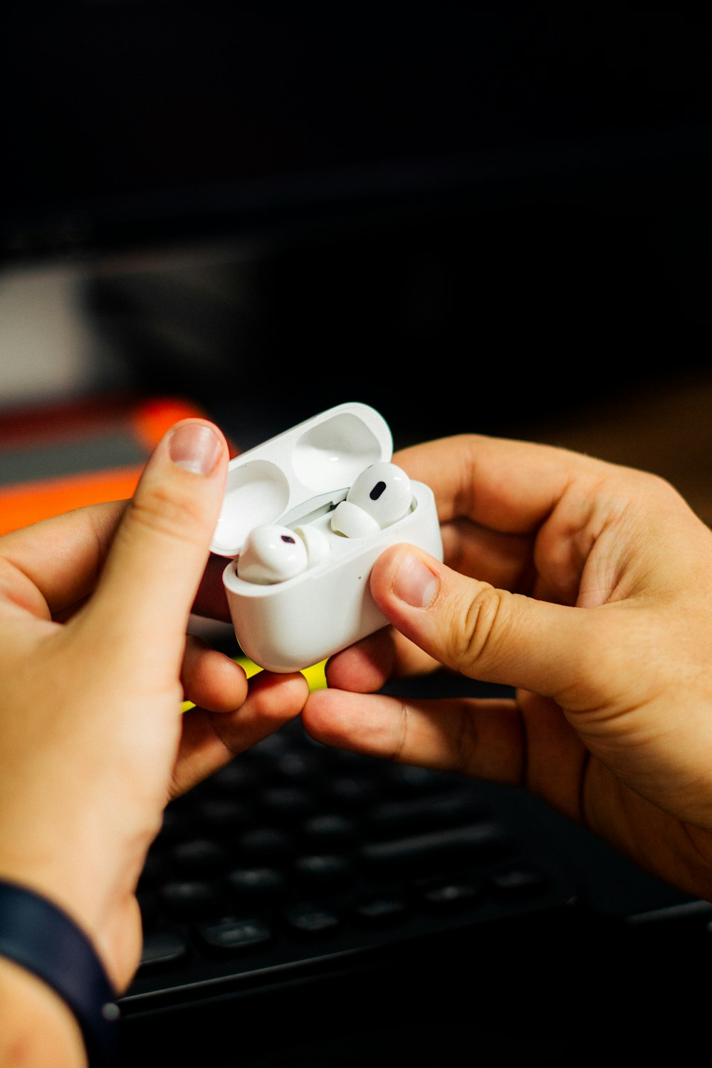 a pair of hands holding a pair of ear buds