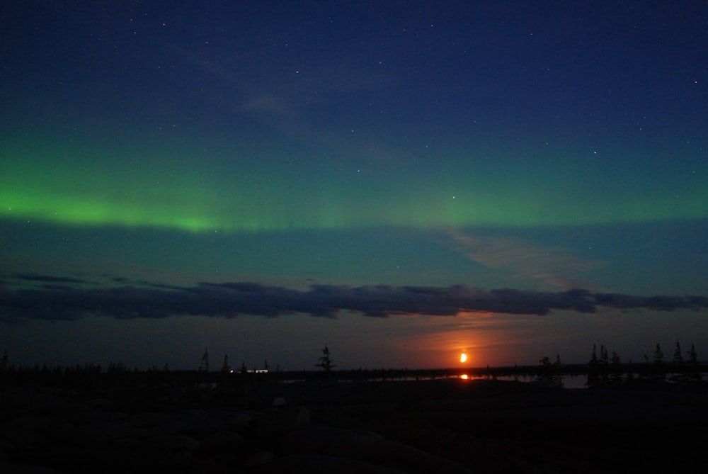 the sun is setting behind the green aurora bore