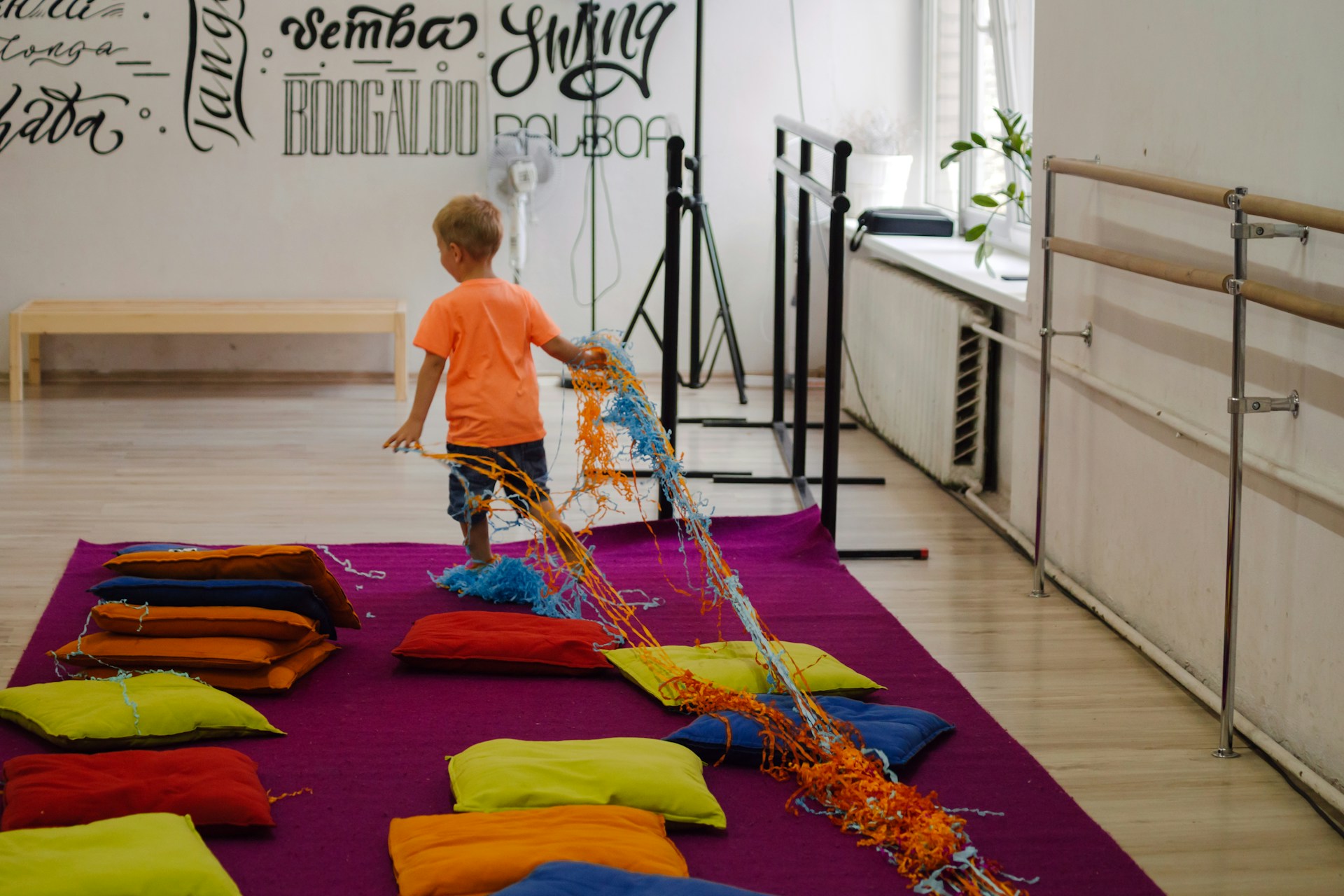 a young boy standing in front of a pile of pillows