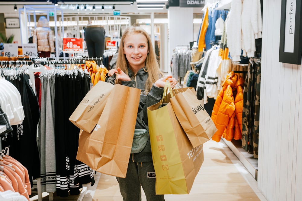 a woman holding shopping bags in a store