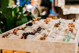 Close-up of delicate, handcrafted bracelets displayed on a rustic wooden tray.