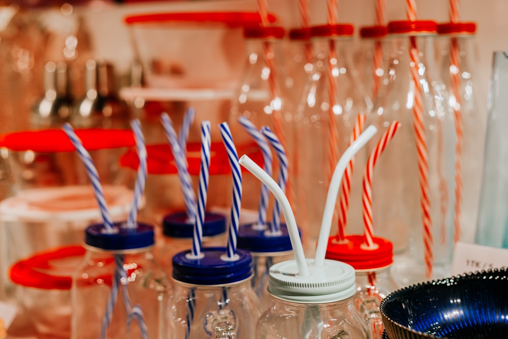 a table topped with bottles filled with drinking glasses and drinking straws