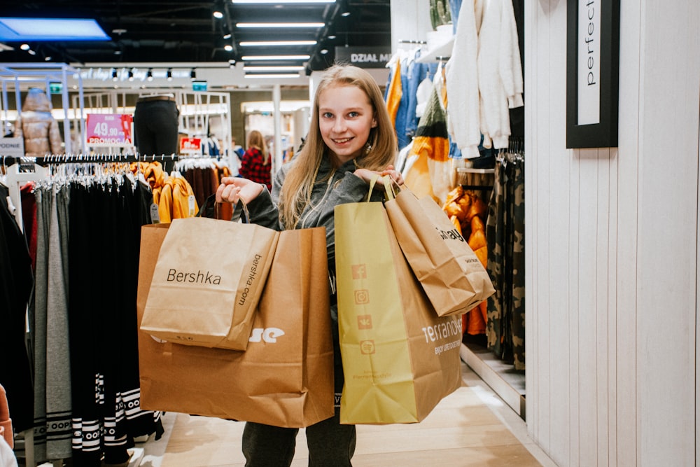 a woman holding two brown bags in a store