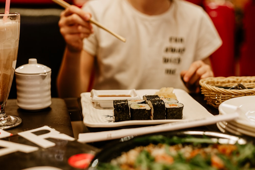 a person sitting at a table with a plate of food