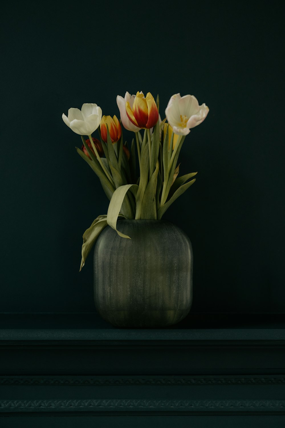 a vase filled with lots of flowers on top of a table