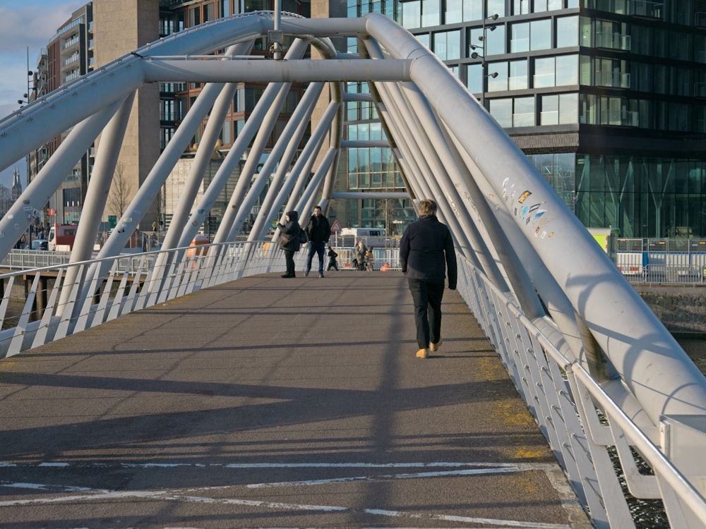 a man walking across a bridge over a river