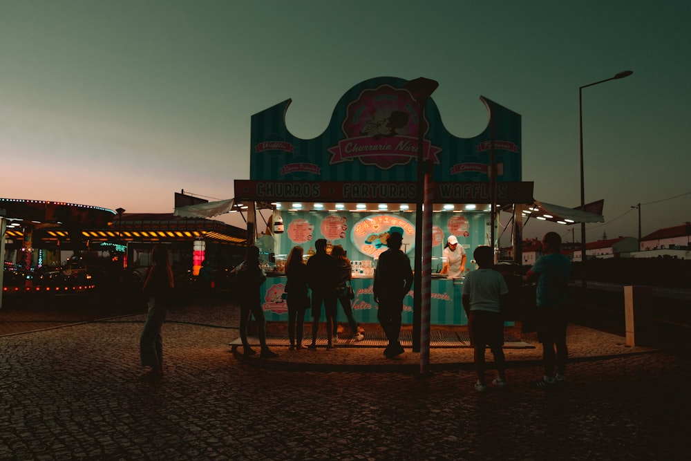 a group of people standing around a carnival booth