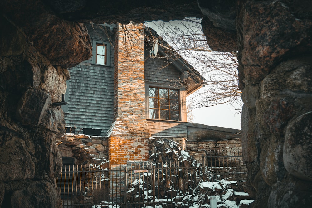 a brick house with a gate and snow on the ground