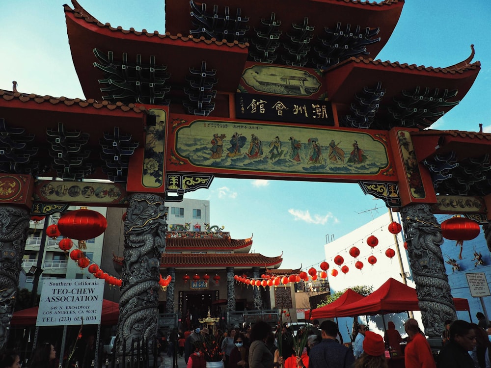 a group of people standing under a red and white arch