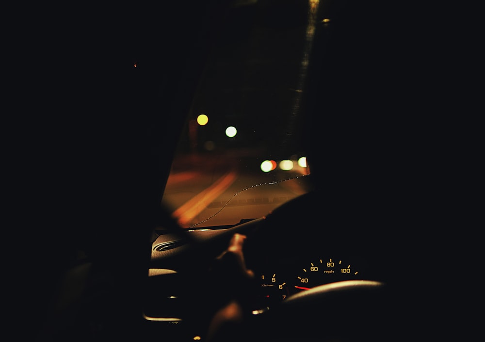 a person driving a car at night in the dark