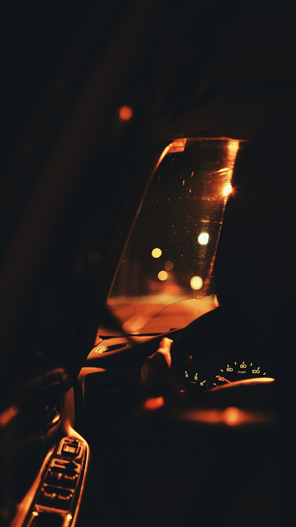a close up of a car mirror with lights in the background