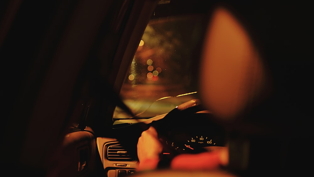 Eine Person, die nachts im Dunkeln ein Auto fährt