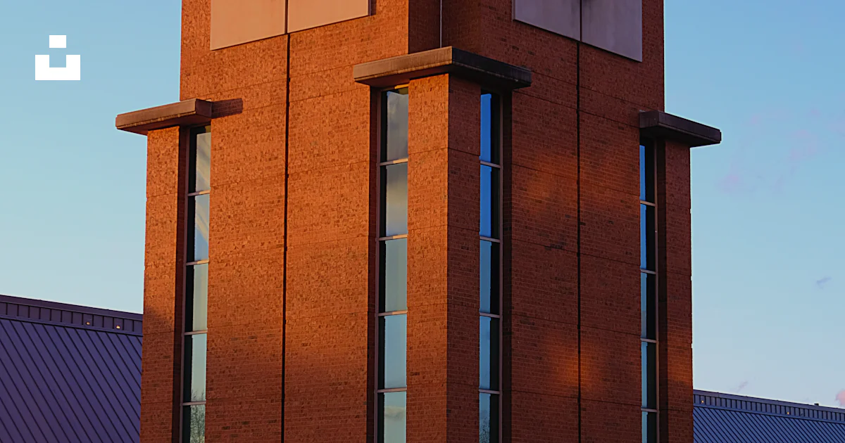 Triangular Clock Tower A tall brick clock tower with a clock on each of it's sides photo ...