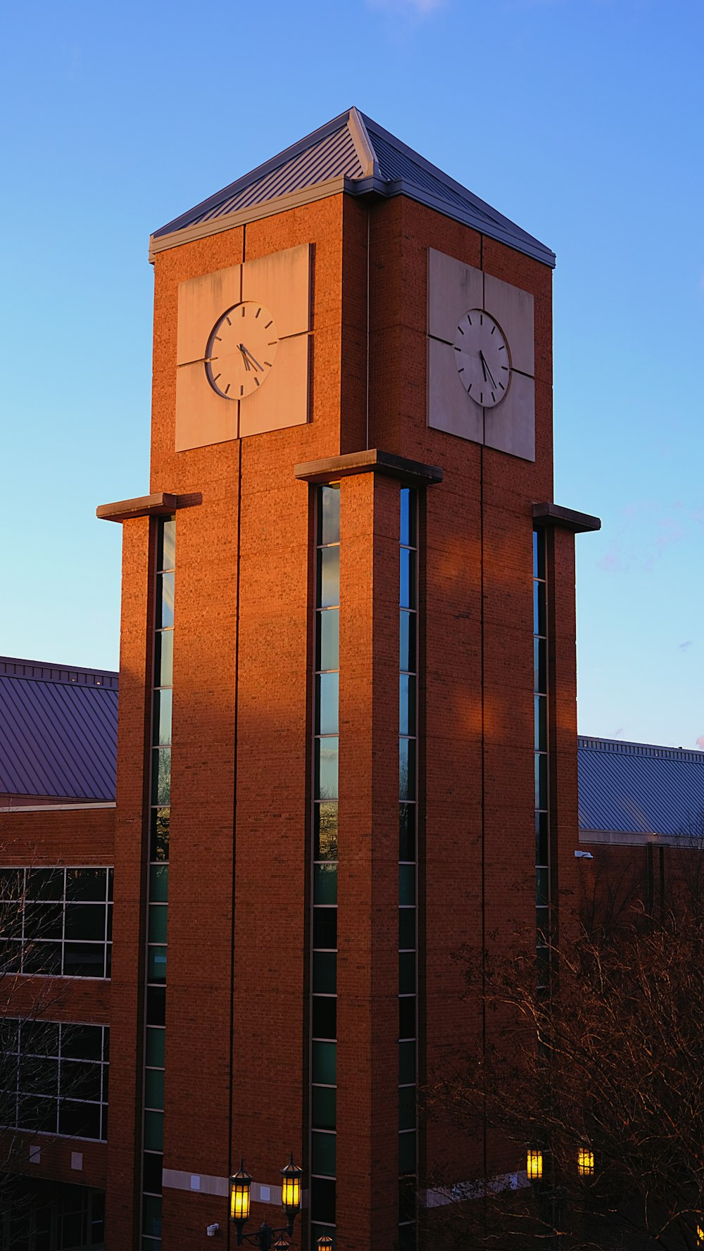 un'alta torre dell'orologio in mattoni con un orologio su ciascuno dei suoi lati