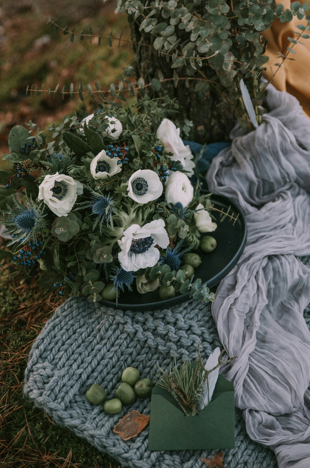 a bouquet of flowers sitting on top of a blanket