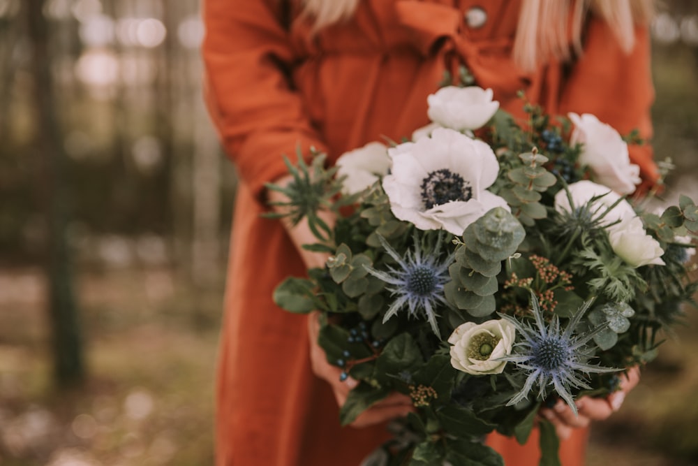 a woman holding a bouquet of flowers in her hands