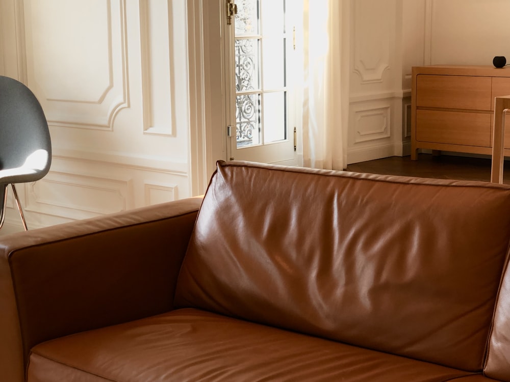a brown leather couch sitting in a living room