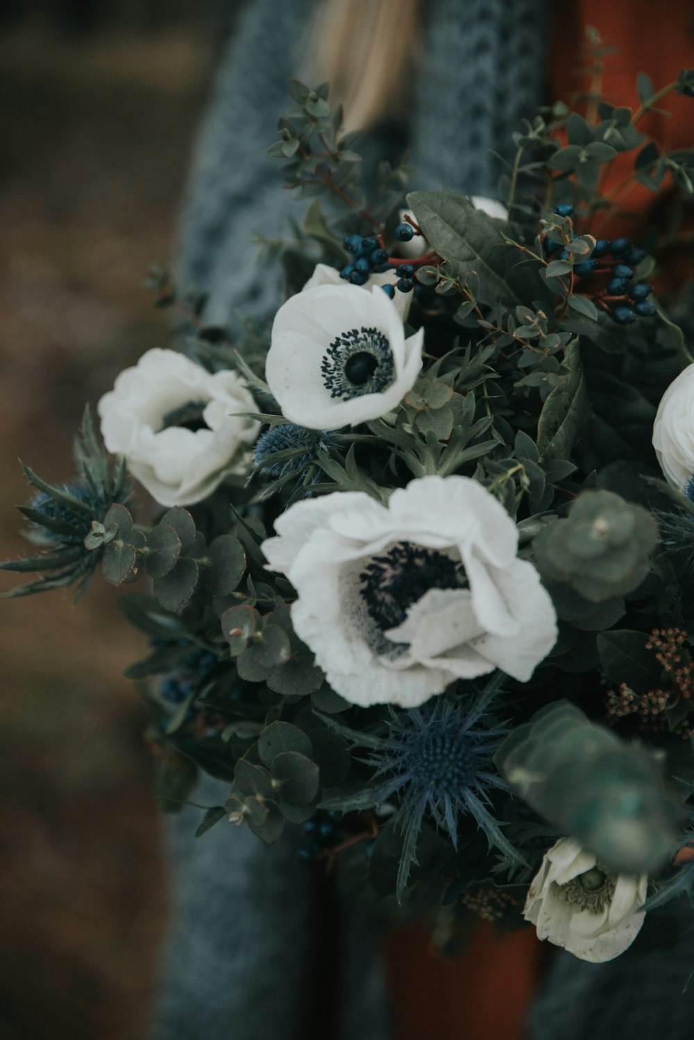 a woman holding a bouquet of white flowers