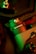 A close-up of a mechanical device labeled 'PAN AXIS MOTOR' with intricate details. The image is illuminated with green and red lighting, creating a striking contrast. Metallic components and switches are visible, suggesting technological and industrial elements.