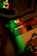 A close-up of a mechanical device labeled 'PAN AXIS MOTOR' with intricate details. The image is illuminated with green and red lighting, creating a striking contrast. Metallic components and switches are visible, suggesting technological and industrial elements.