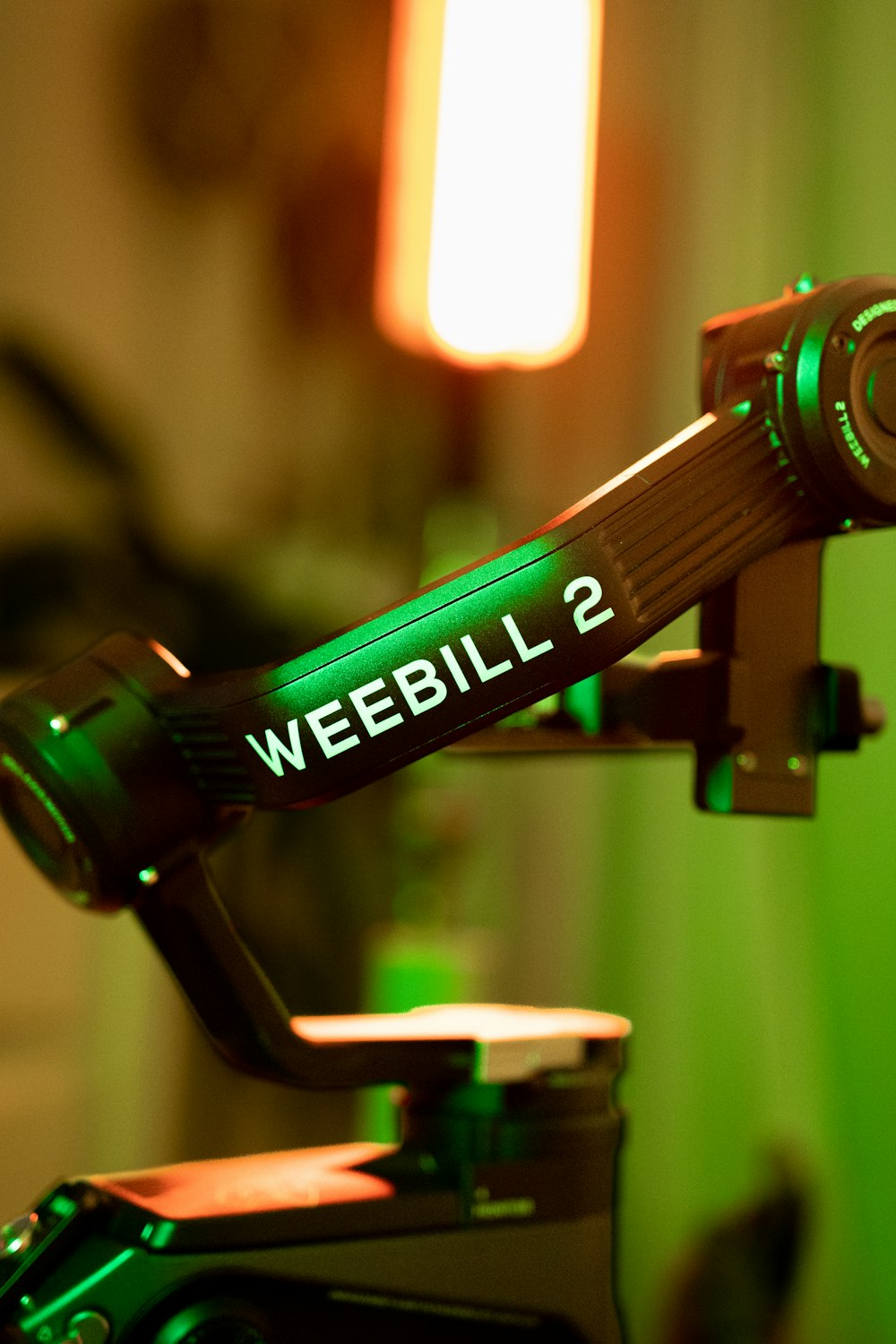 a close up of a camera with a green light in the background