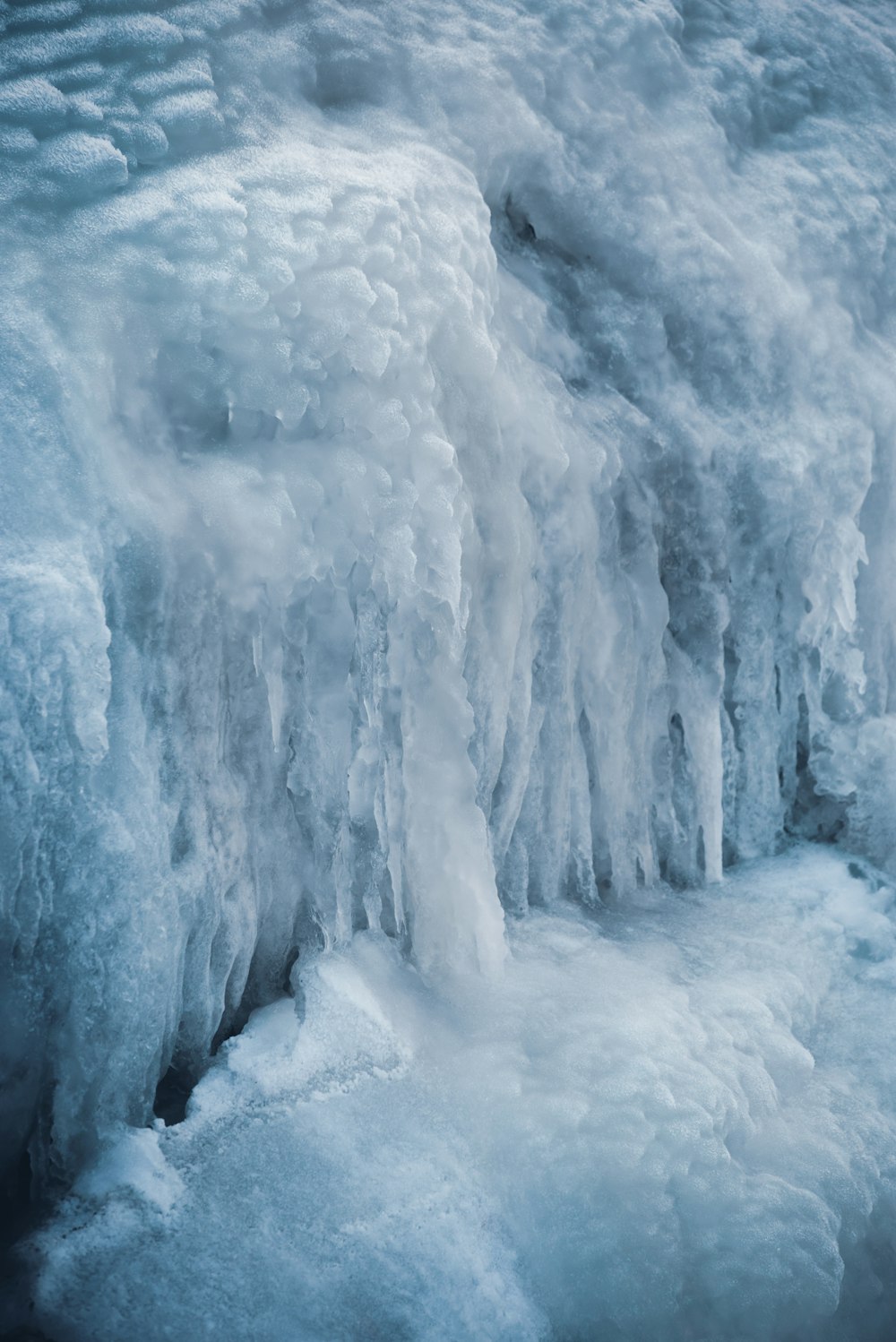 a man standing in front of a frozen waterfall