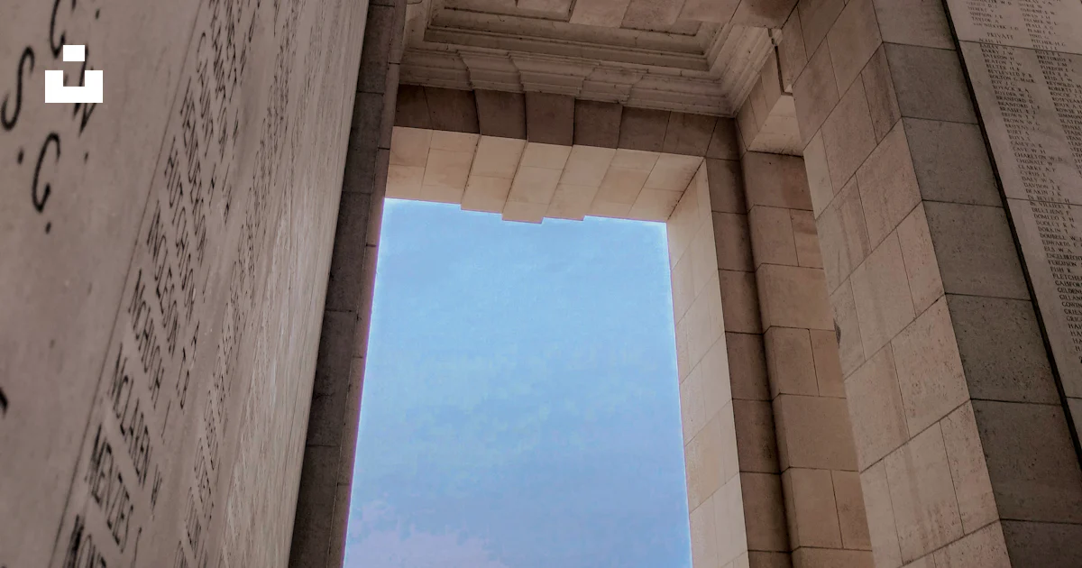 An arch with writing on it and a clock tower in the background photo ...