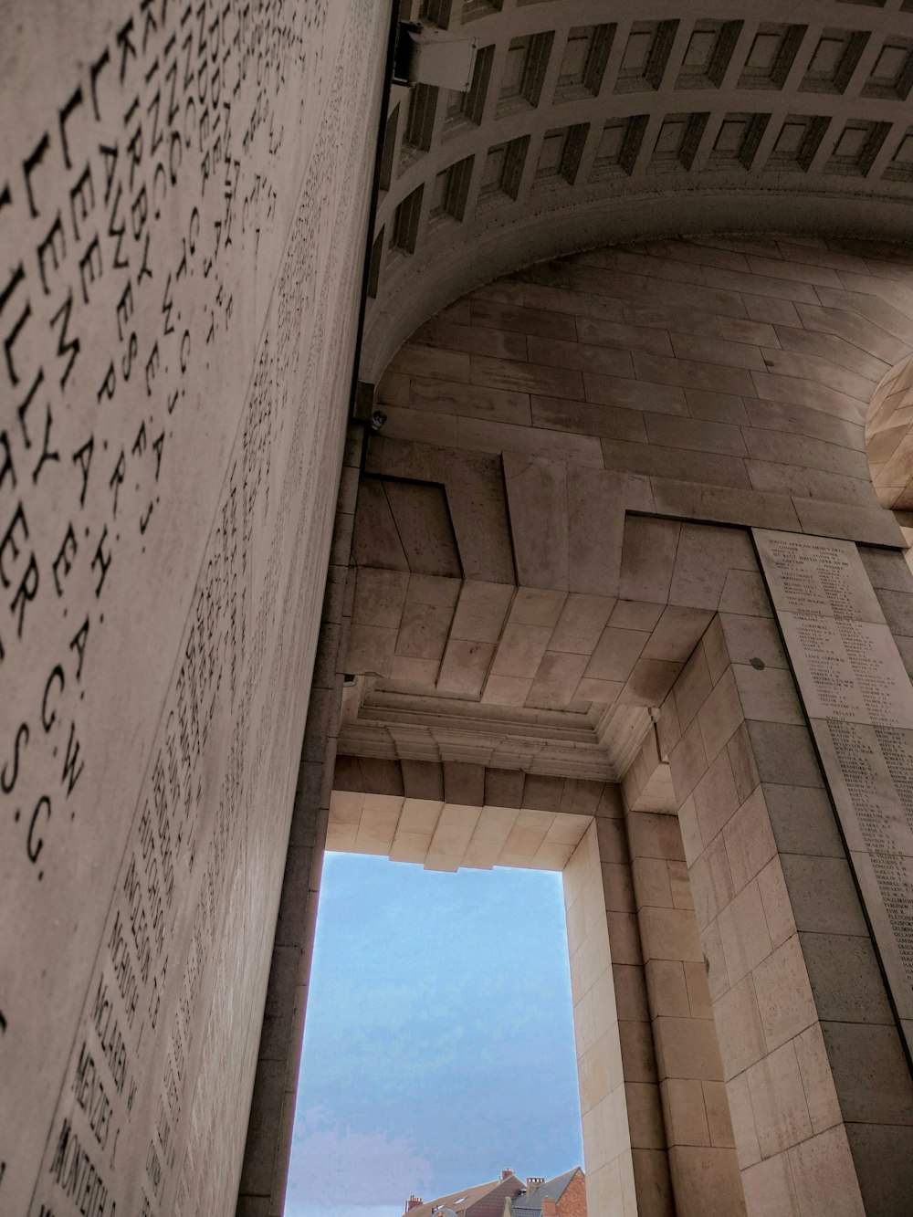 an arch with writing on it and a clock tower in the background