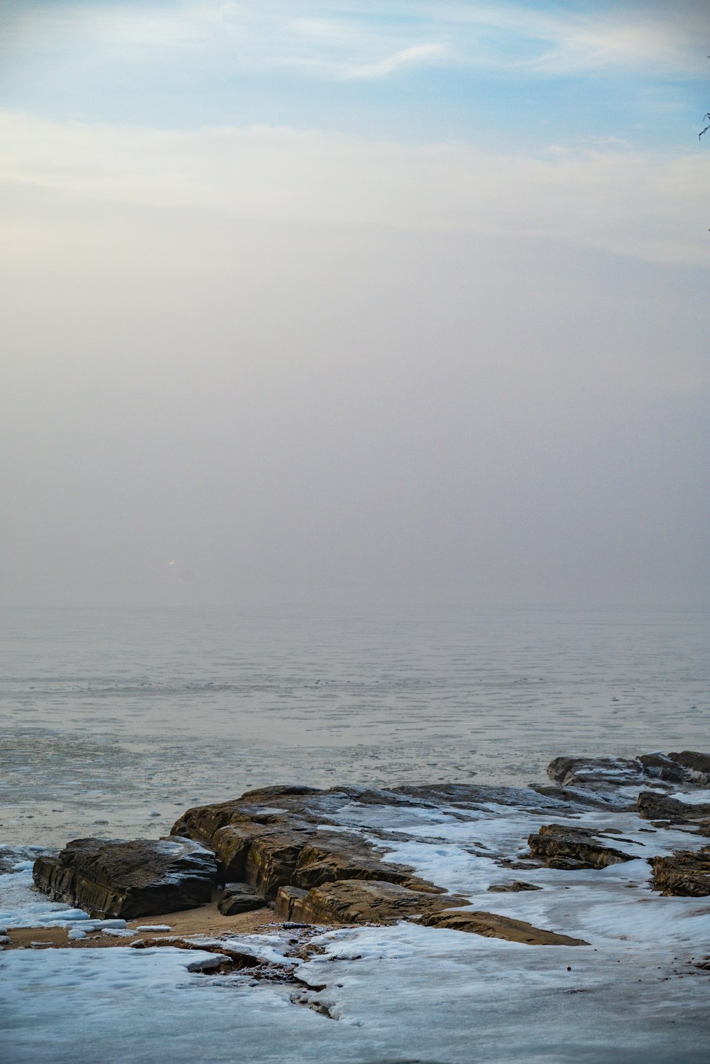 a lone boat in the distance on a foggy day