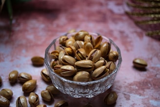 a glass bowl filled with nuts on top of a table