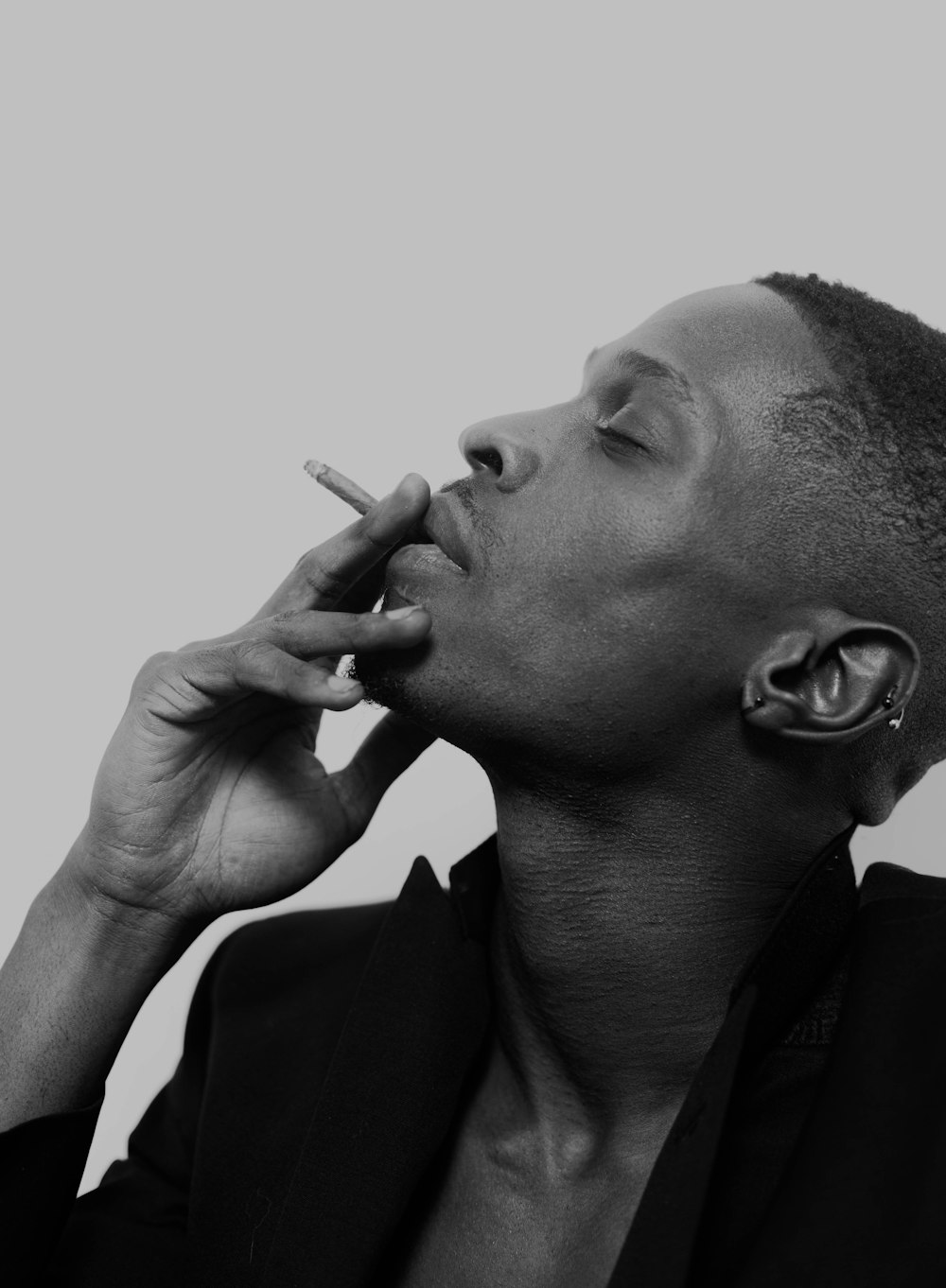 a man smoking a cigarette in a black and white photo