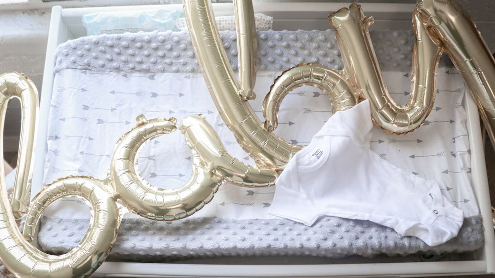 a white shirt and some gold foil balloons