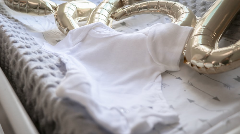 a baby in a white shirt laying in a crib