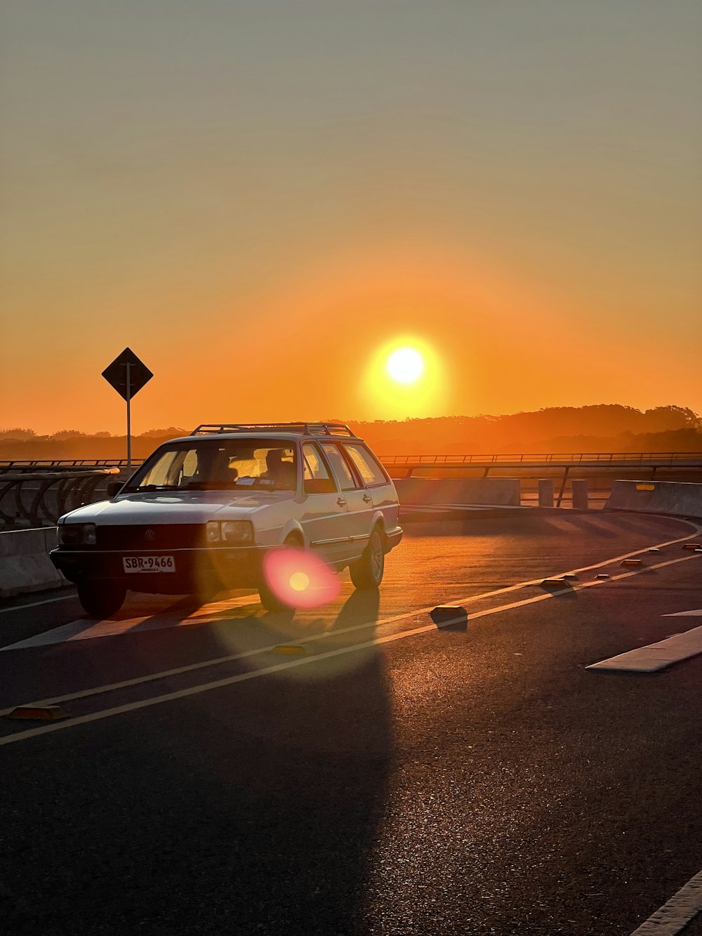 a car driving down a road at sunset