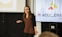 a woman standing in front of a projection screen