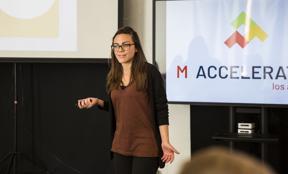 a woman standing in front of a projection screen