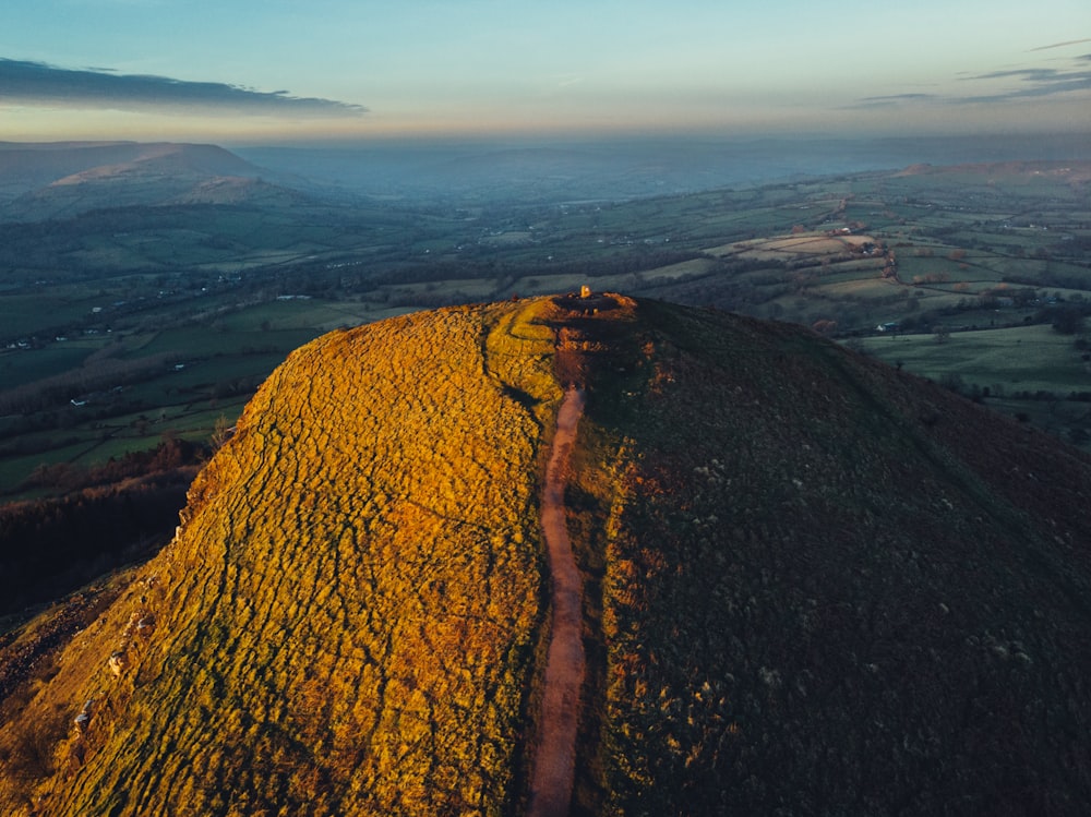 uma vista aérea de uma estrada de terra em uma colina