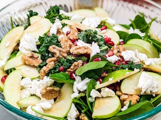 a salad with apples, spinach, walnuts and feta cheese