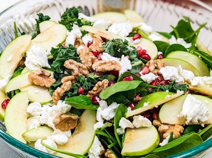 a salad with apples, spinach, walnuts and feta cheese
