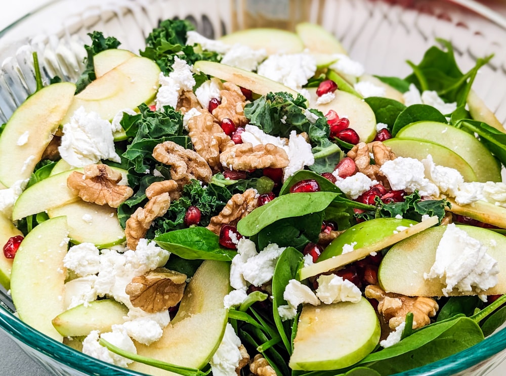 a salad with apples, spinach, walnuts and feta cheese