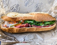 A delicious baguette filled with fresh vegetables and meats.