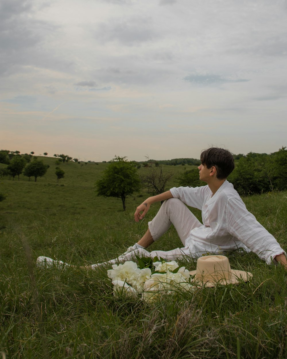 a man sitting on a blanket in the middle of a field