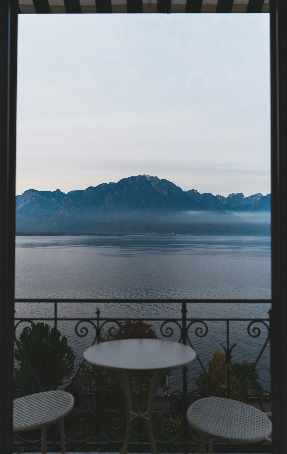 a table and chairs on a balcony overlooking the water