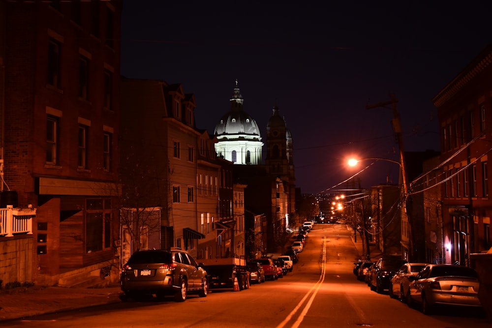 a city street at night with a church in the background
