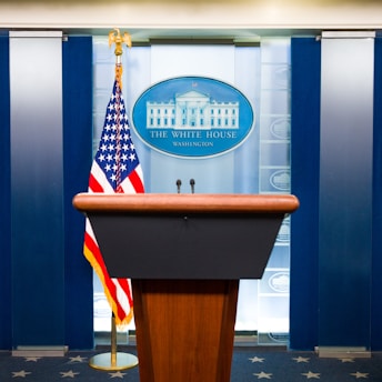 a podium with an american flag and the white house