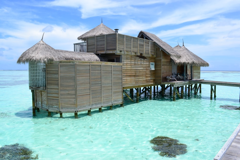 a house on stilts in the water with a dock