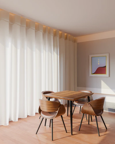 A stylish dining area with a sleek wooden table and comfortable chairs set against a bright window.