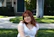 a woman sitting on the grass in front of a house