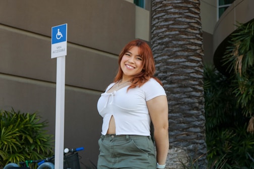 A friendly driver assisting a passenger into a wheelchair-accessible van outside a sunny West Palm Beach clinic.