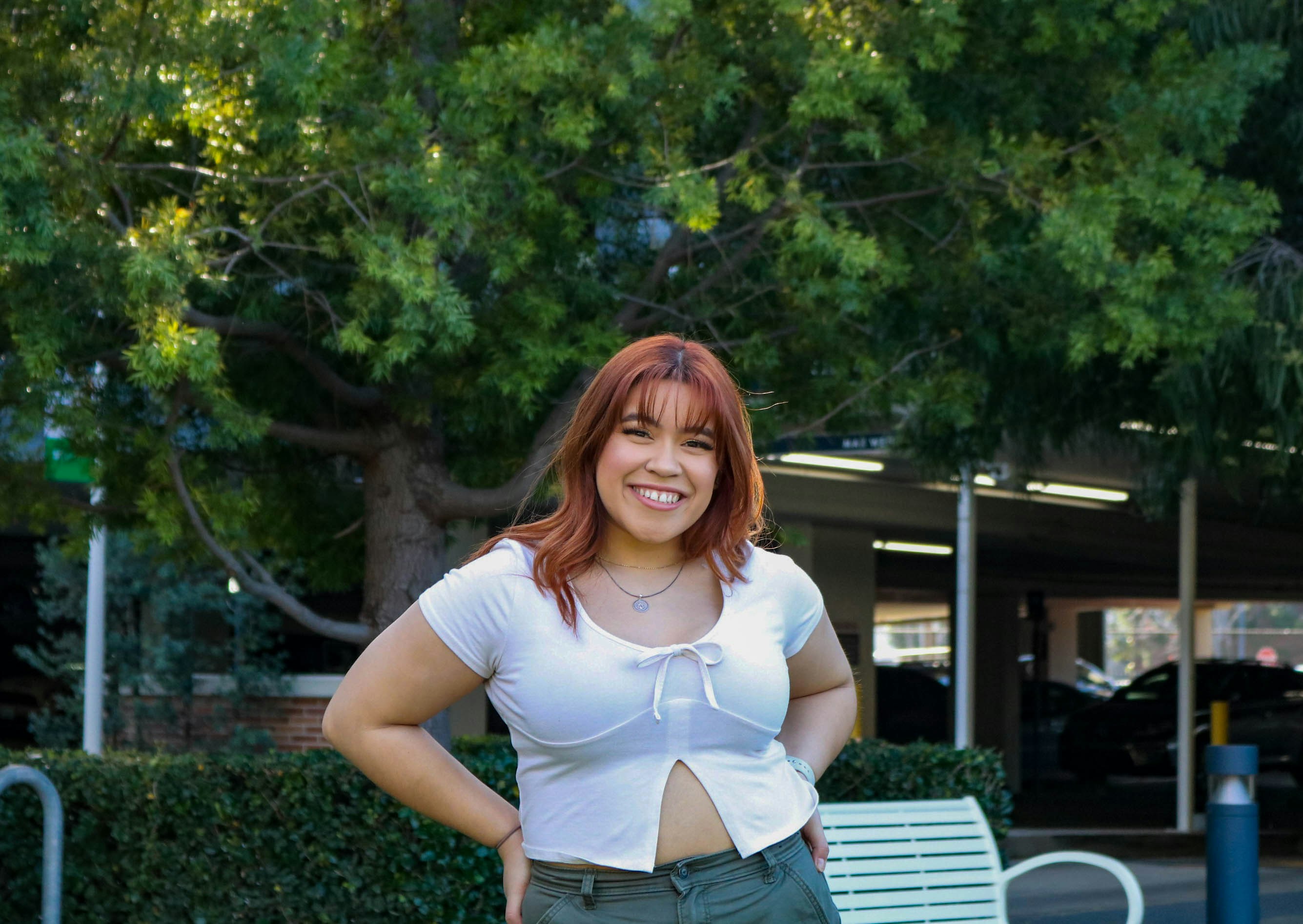 a woman standing in front of a park bench